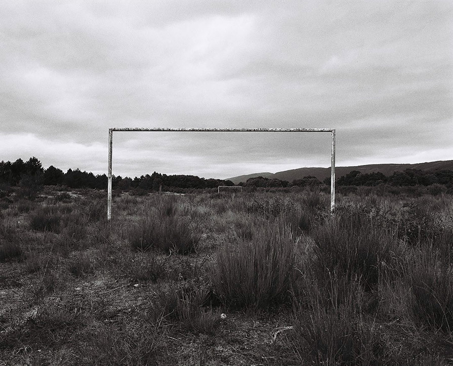 Vue en perspective des cages d'un ancien terrain de football désaffecté envahi par les ajoncs, non loin de Maceda, en Galice