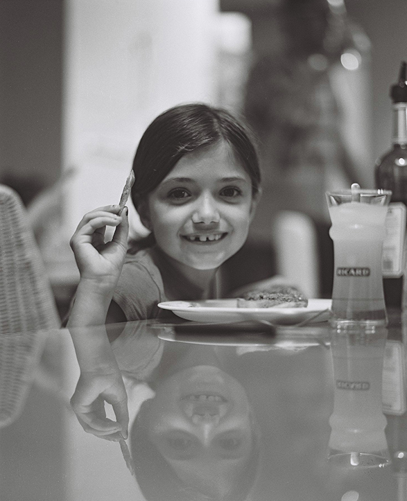 Portrait d'une fille d'une amie souriante, en train de manger des frites