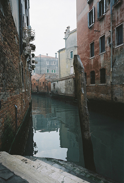 Photographie de rue montrant un matelas et quelques affaires appartenant à un SDF à Lyon, avec en perspective 2 hommes de dos discutant